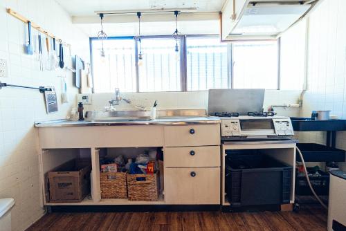 a kitchen with a sink and a counter at yururito guesthouse in Matsumoto