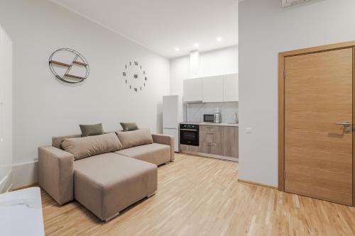 a living room with a couch and a kitchen at Marmor House in Rīga