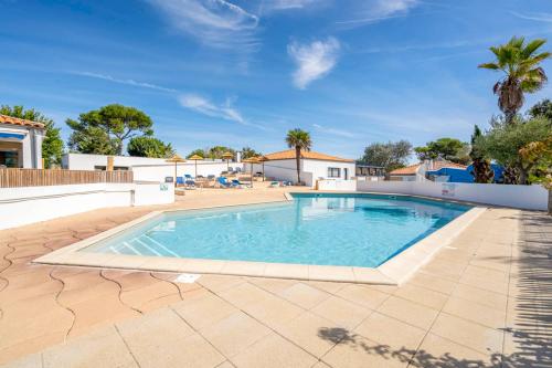 - une piscine au milieu d'une terrasse avec un ciel bleu dans l'établissement Camping Paradis 4 étoiles A La Corniche La Rochelle Angoulins, à Angoulins-sur-Mer