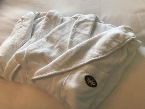 a white shirt laying on top of a bed at Hotel Monterey Grasmere Osaka in Osaka
