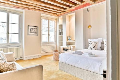 une chambre avec un lit blanc et une chaise dans l'établissement Chic appartement dans le prestigieux 7ème arrondissement, à Paris