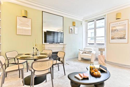 un salon avec des tables, des chaises et une télévision dans l'établissement Chic appartement dans le prestigieux 7ème arrondissement, à Paris