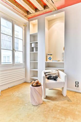 - un salon avec une chaise blanche et une table dans l'établissement Chic appartement dans le prestigieux 7ème arrondissement, à Paris