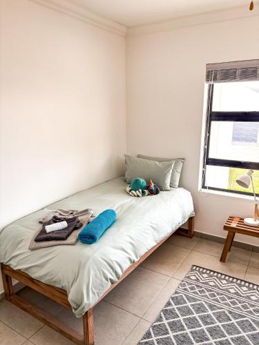 a bedroom with a bed with a stuffed animal on it at 21 On the Green in Stompneusbaai