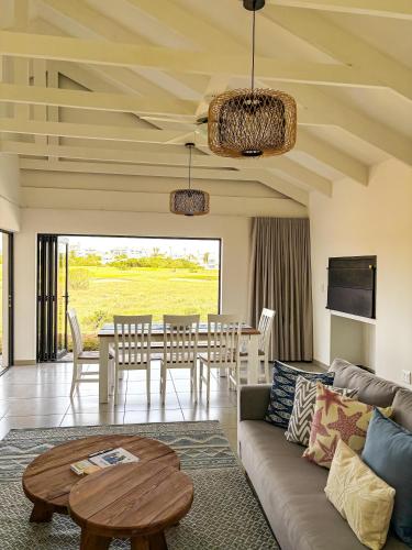 a living room with a couch and a table at 21 On the Green in Stompneusbaai
