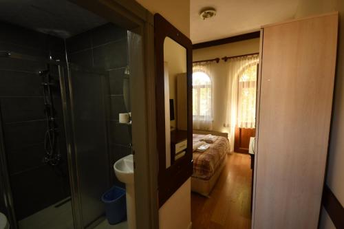 Baño con dormitorio con cama y espejo en Sena Hotels, en Ürgüp