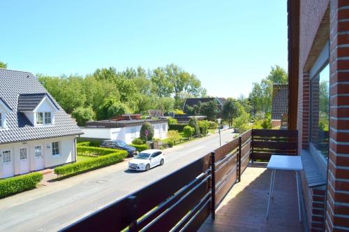 a balcony with a car parked on a street at Wiesenweg - Wohnung 06 in Wyk auf Föhr
