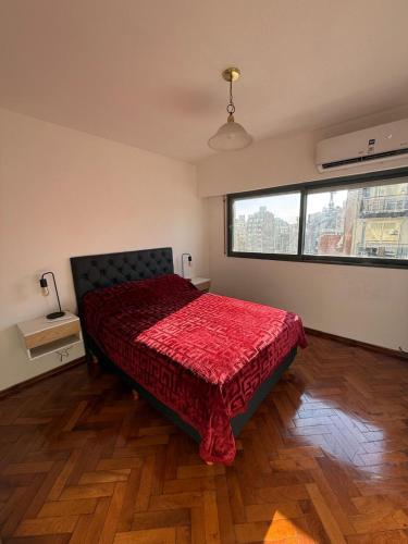 a bedroom with a bed with a red comforter at Aloha II in Rosario