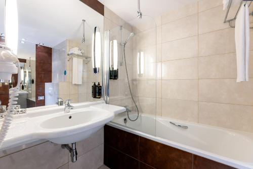 a bathroom with a sink and a bath tub at Mercure Karpacz Skalny in Karpacz