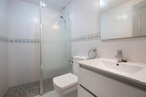 Un baño con inodoro, lavabo y ducha. en Benalmar Bajo C, en Arroyo de la Miel