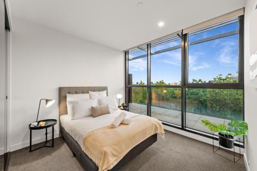 a bedroom with a bed and a large window at Parkside Perfection Near The CBD in Melbourne