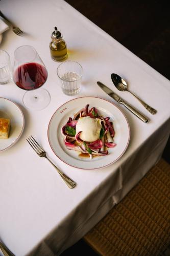 a white table with a plate of food on it at Parkhotel Mondschein, a Member of Design Hotels in Bolzano