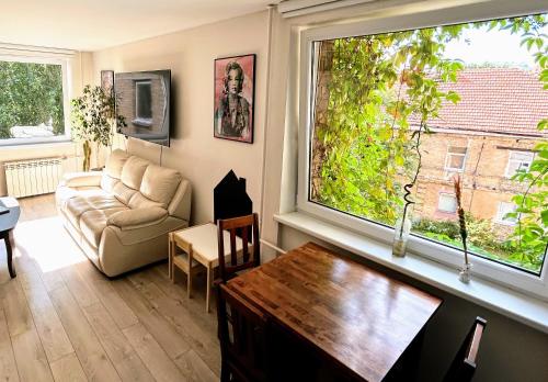 a living room with a couch and a large window at Algirdo Apartments, Self Check-in, Free Private Parking in Vilnius