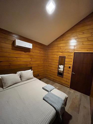 a bedroom with a large white bed with wooden walls at Eco Casa Mango Lepanto #10 in Lepanto