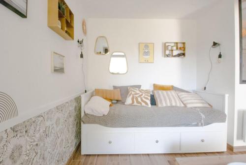 - une chambre blanche avec un lit et des oreillers dans l'établissement Studio Vue Mer à Kerfany Plage, à Moëlan-sur-Mer