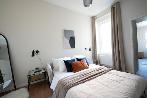 a bedroom with a large white bed with pillows at Stockholm Style Designer in Limpertsberg in Luxembourg