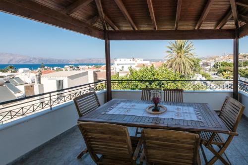 a table and chairs on a balcony with a view at Kaloudis Apartment in Kissamos