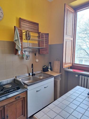 a kitchen with a sink and a stove and a window at Oak Tree in Montefelcino