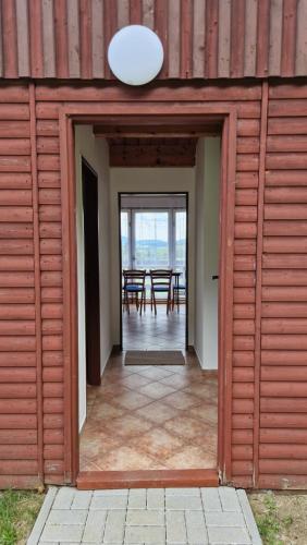 an open door of a building with a table in the background at Chatová osada Hájovna in Kdyně