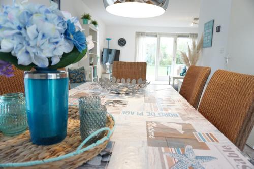 a dining room table with a blue flower in a blue vase at Kustverhuur, Breskens Zwin 089 in Breskens