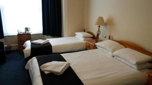 A bed or beds in a room at Ashwood Hotel