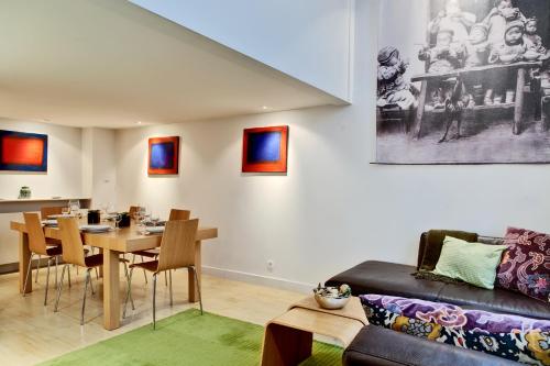 un salon avec une table et un canapé dans l'établissement Jardin des Rosiers résidence, à Paris