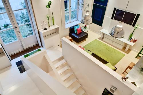 une vue de tête sur un salon avec un escalier dans l'établissement Jardin des Rosiers résidence, à Paris