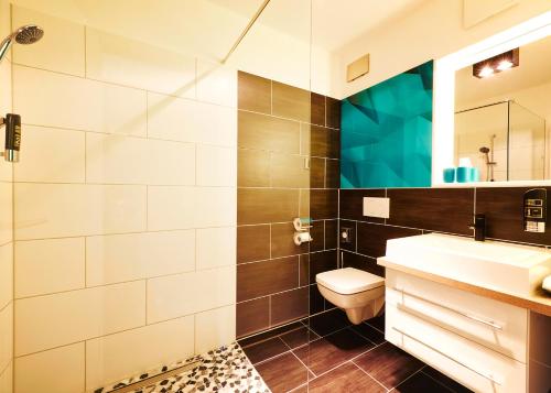 uma casa de banho com um lavatório, um WC e um espelho. em Travelinjoy em Rietheim-Weilheim
