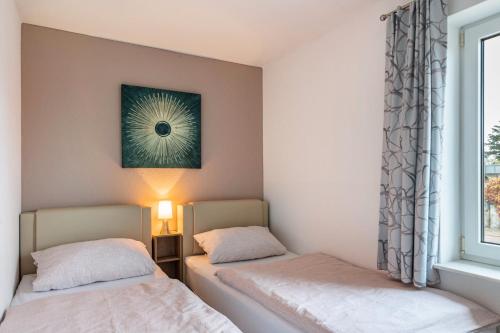 zwei Betten in einem Zimmer mit Fenster in der Unterkunft Domizil Eden - Erdgeschoss in Göhren-Lebbin