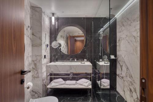 a bathroom with a sink and a mirror at Electra Palace Thessaloniki in Thessaloniki