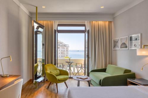 a hotel room with a bed and a living room at Electra Palace Thessaloniki in Thessaloniki