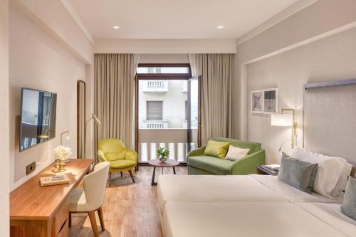a hotel room with a bed and a table and chairs at Electra Palace Thessaloniki in Thessaloniki
