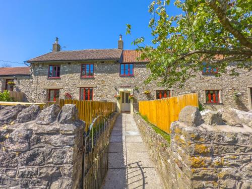 a stone house with a fence in front of it at Spacious-Rustic Cottage-Dog Friendly-w log burner in Worle