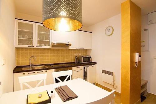 a kitchen with a table and a clock on the wall at Apartmány - Helena 15 a Helena 21 Hrabovo in Ružomberok