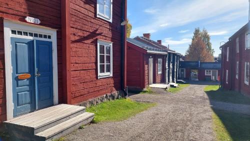 a row of red houses with a blue door on a street at STF Hostel Vilhelmina Kyrkstad in Vilhelmina