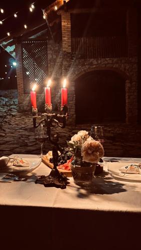 a table with a candle and plates of food on it at Crâșma Trei Fântâni - Cebotaru in Hogineşti