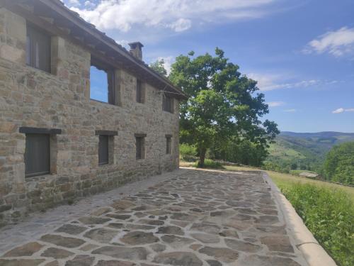 a stone walkway next to a stone building at Cabaña Pasiega El Ojal in San Pedro del Romeral