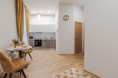 a living room with a table and chairs and a kitchen at Marmor House in Rīga