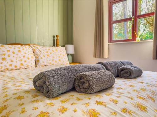 ein Bett mit einer Bettdecke und Handtüchern darauf in der Unterkunft Cosy & Characterful, Seaside Cottage, Dog Friendly in Worle