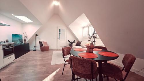 a living room with a dining room table and a kitchen at Tante Bed 44A in Voorschoten