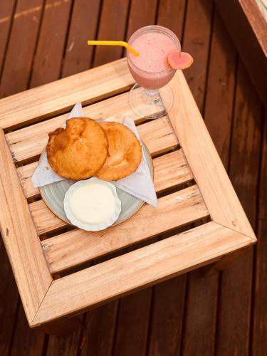a wooden tray with a plate of food and a drink at Isla Única- Islas del Rosario in Isla Grande