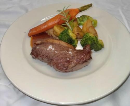 a plate of meat and vegetables on a white plate at Chambres d'hôtes à Pêtre in Entrevennes