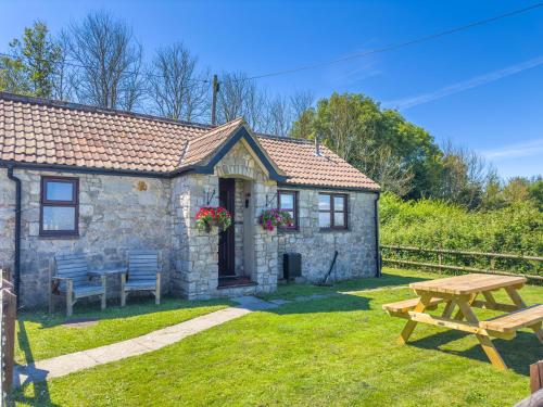 a stone cottage with a picnic table and a picnic table at Cosy & Characterful, Seaside Cottage, Dog Friendly in Worle