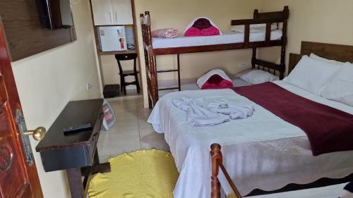 a bedroom with a bed and two bunk beds at Suites Bella vista in Campos do Jordão