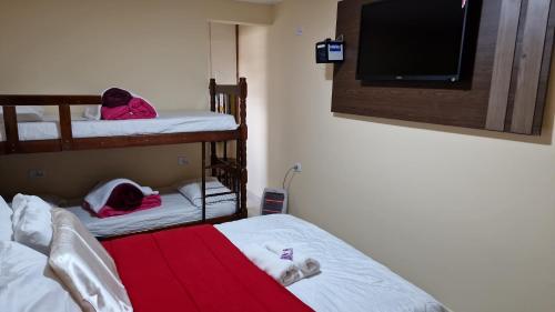 a small room with two bunk beds and a tv at Suites Bella vista in Campos do Jordão