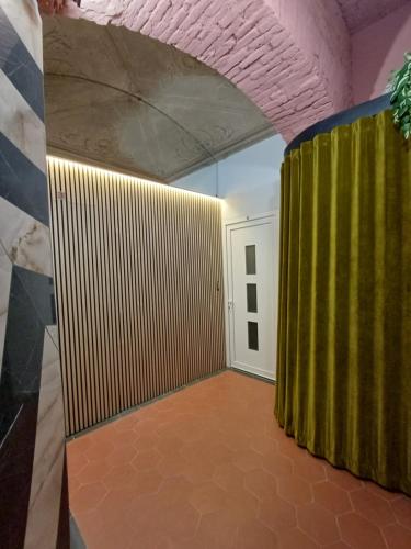 a room with a green curtain and a door at ArtDecò Rooms Turin in Turin