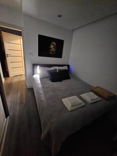 a bedroom with a large bed with two towels on it at Family Apartament in Zamość