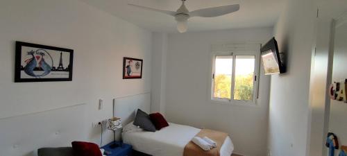 a small bedroom with a bed and a window at Apartamento TomCar Piscina, Pádel, wifi y zonas comunes in Sanlúcar de Barrameda