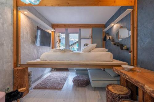 une chambre avec un grand lit et un miroir dans l'établissement Lognan- New studio in the city center - By Cozee Rentals, à Chamonix-Mont-Blanc