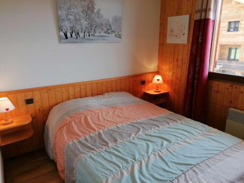 - une chambre avec un lit, une fenêtre et 2 lampes dans l'établissement Appt 2 pièces pour 5 pers avec balcon et parking à Chinaillon, près des pistes - FR-1-241-121, au Grand-Bornand